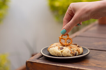 Woman hand taking a pretzel with cookies