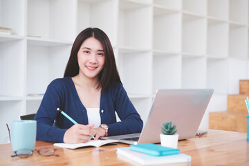Beautiful young asian freelancer business woman working with computer laptop in co-working space or coffee shop.