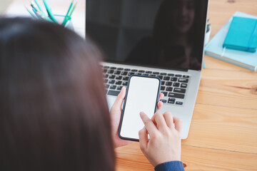 Cropped shot of female hands holding, using smart phone with blank screen for your text message or information content.