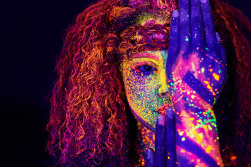You cant block out true colour. Cropped portrait of a young woman posing with neon paint on her face.