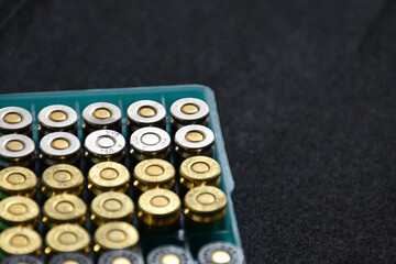9MM pistol bullets in plastic box on black background, concept for training and practising the gun shooting to protect oneself and security guard around the world, soft and selective focus.