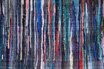 Multicolored handmade floor rug made out of recycled rags as background
