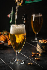 Glass of light beer on dark background. Selective focus