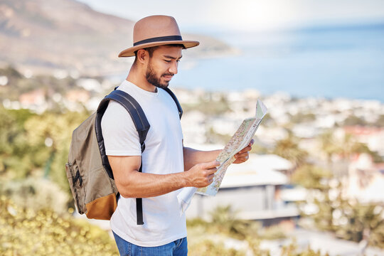 Im not lost, Im just exploring. Shot of a young man holding a map while exploring outdoors.