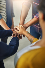 United in the name of creativity. Shot of a team of unidentifiable creatives piling their hands together in the office.