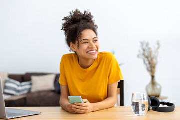 Fototapeta na wymiar Portrait of successful young African American woman freelance in casual clothes working at home office or coworking while sitting at workplace