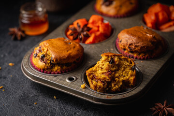 Homemade spicy pumpkin muffins or cupcakes with chocolate on a metal rack. Autumn dessert. Selective focus