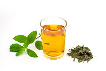 Tulsi or holy basil tea in transparent cup with fresh and dry tulsi leaf isolated on white...