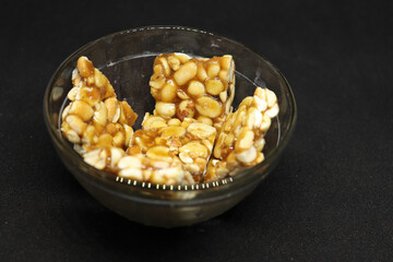 Peanut candy is in a bowl. with Black background