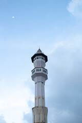 Fototapeta na wymiar Mosque minaret and moon with clear sky in the afternoon