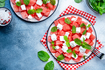Refreshing summer juicy Watermelon salad with feta cheese and fresh mint, gray table background, top view, copy space
