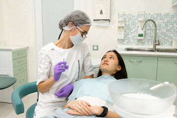 doctor dentist doing medical stomatology examination for woman patient, using professional tools