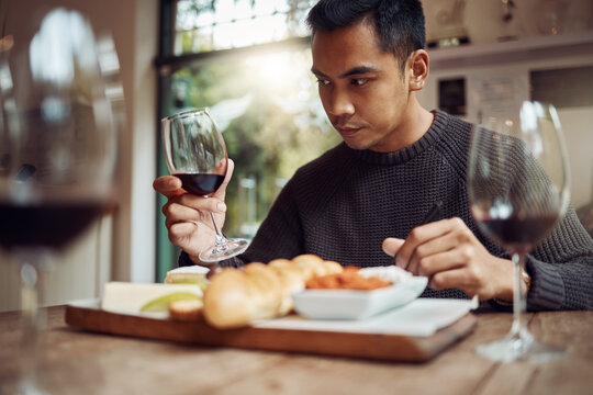 Use All Of Your Senses. Shot Of A Man Enjoying A Cheese Platter And Tasting Different Wines.