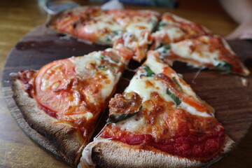 child eating delicious pizza on the wooden plate close-up