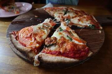 child eating delicious pizza on the wooden plate close-up