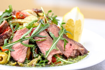 Rare roast beef meal with organic root vegetables