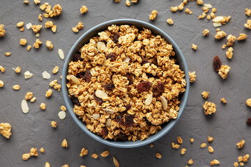 Homemade Granola with raisins and almonds  in a Bowl on a gray surface, top view. Flat lay, overhead, from above.