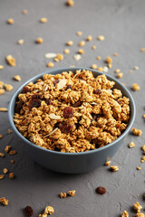 Obraz na płótnie Canvas Homemade Granola with raisins and almonds in a Bowl on a gray background, side view.