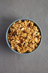 Homemade Granola with raisins and almonds  in a Bowl on a gray background, top view. Flat lay, overhead, from above.