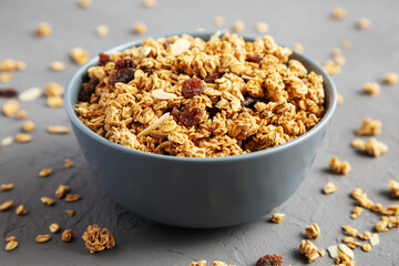 Homemade Granola with raisins and almonds  in a Bowl on a gray background, side view. Close-up.
