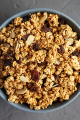 Homemade Granola with raisins and almonds  in a Bowl on a gray background, top view. Flat lay, overhead, from above.