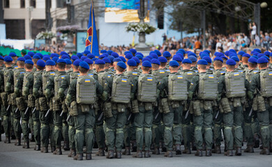A column of Ukrainian servicemen walks the streets of Kyiv. Close-up, selective focus.
