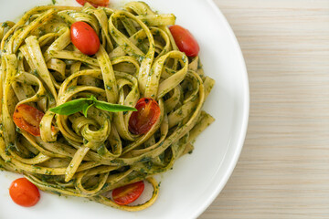 fettuccine spaghetti pasta with pesto sauce and tomatoes