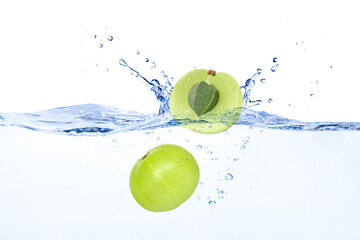 Indian gooseberry (phyllanthus emblica, Amla) falling in water splash isolated on white background. 