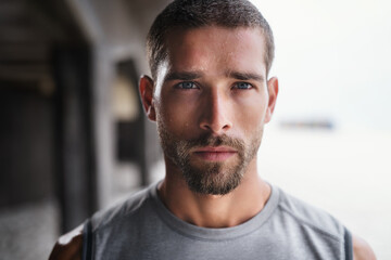 Hes not playing ant games about his fitness. Portrait of a handsome young sportsman looking serious while exercising outdoors.