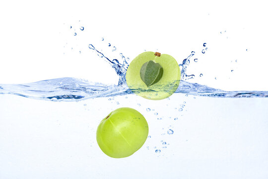 Indian Gooseberry (phyllanthus Emblica, Amla) Falling In Water Splash Isolated On White Background. 