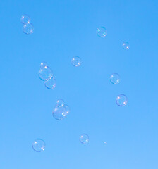 Soap bubbles fly against the sky.