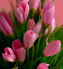Fototapeta premium Artificial pink flowers on a pink background.