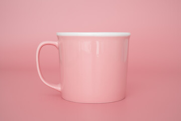 Pink cup for hot drinks tea or coffee on pink background