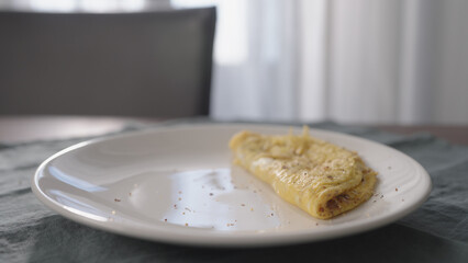 white plate with omelette on wood table