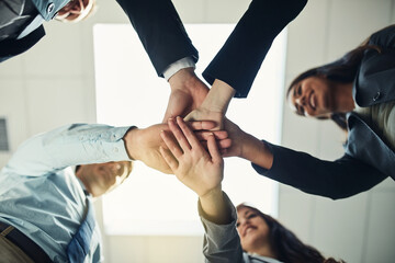 Come together and make it happen. Cropped shot of a group of businesspeople joining their hands in...