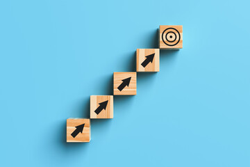 Wooden blocks with arrows and a target on a blue background. The concept of going to the goal. 3d rendering.