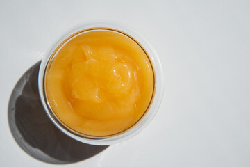 texture of golden honey in a transparent container on a white background free space for text.sunflower honey