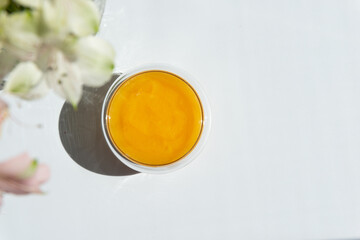 texture of golden honey in a transparent container on a white background free space for text.sunflower honey