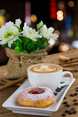 Donut and Latte Coffee in white plate on wooden table