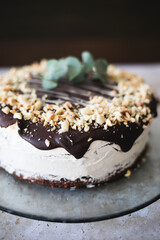 Detail of a chocolate cake, cream and almonds, on a glass plate