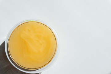 texture of yellow honey in a transparent container on a white background free space for text..cotton honey