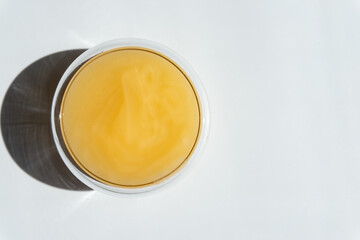 texture of yellow honey in a transparent container on a white background free space for text..cotton honey