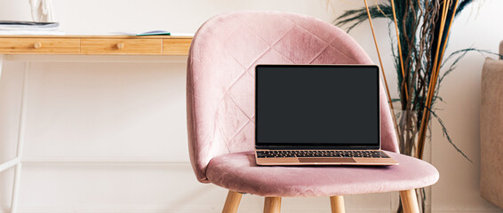 Laptop with blank white screen on office desk interior. Stylish rose gold workplace mockup table...