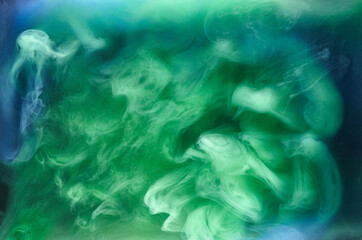 Blue green smoke on black ink background, colorful fog, abstract swirling ocean sea, acrylic paint pigment underwater
