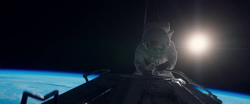 Behind the scenes of commercial shot - Caucasian female astronaut stuntwoman hanging on a wires, wearing a spacesuit