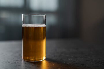 Apple cider in tumbler glass on concrete countertop with copy space