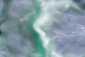 Green gray smoke on black ink background, colorful fog, abstract swirling touch ocean sea, acrylic paint pigment underwater