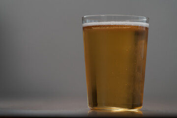 Apple cider in tumbler glass on walnut wood table with copy space