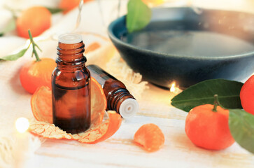 Tangerine Essential oil orange mandarin, relaxing aromatherapy set beauty treatment scent product, glass dropper bottles, citrus fruit, soft candle light. 
Comfy home atmosphere, golden sparkling boke - obrazy, fototapety, plakaty