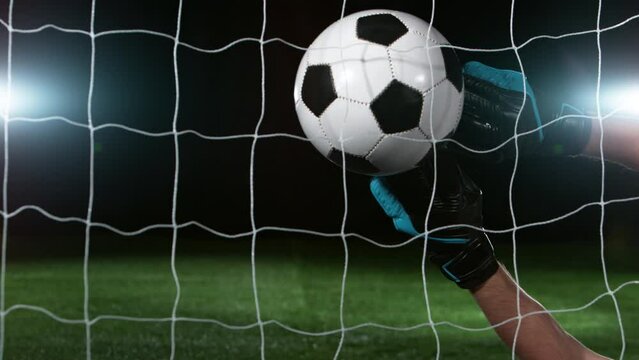 Goalkeeper catches soccer ball, close up, slow motion at 1000 fps. Filmed on high speed cinematic camera.